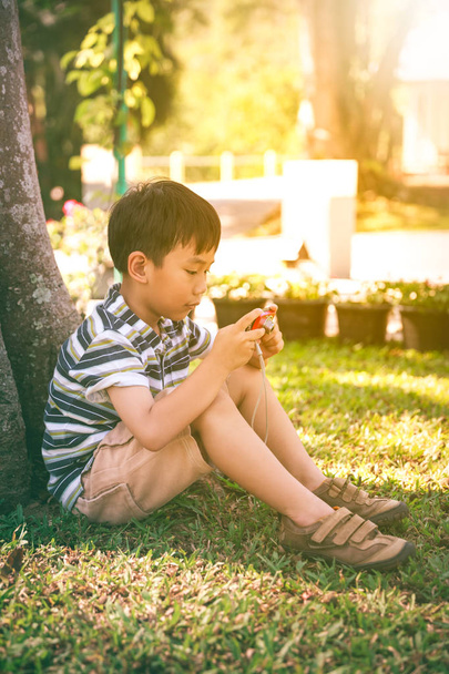 Boldog ázsiai fiú kamera pihentető a szabadban a nap idő, utazás, nyaralás.  - Fotó, kép