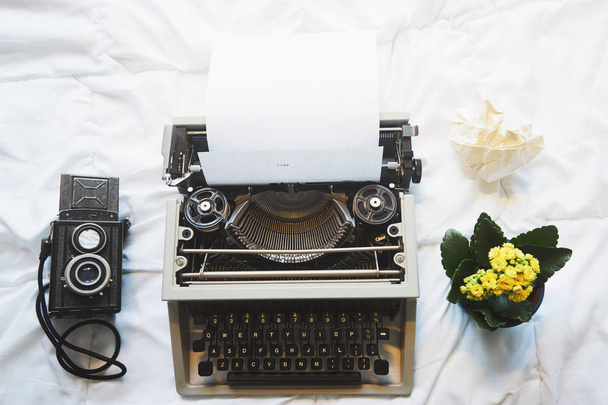 Máquina de escribir vintage y cámara en la cama
 - Foto, Imagen