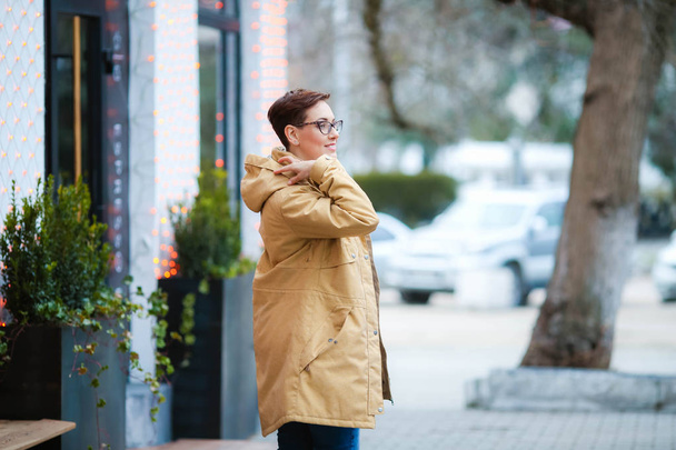 Mladá krásná žena v brýlích, krátká módní hairstylein v kanceláři oblečení, sako, procházka ulicemi, jaro procházky - Fotografie, Obrázek