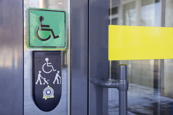Señal de usuarios de sillas de ruedas en la puerta principal del edificio de oficinas
 - Foto, imagen