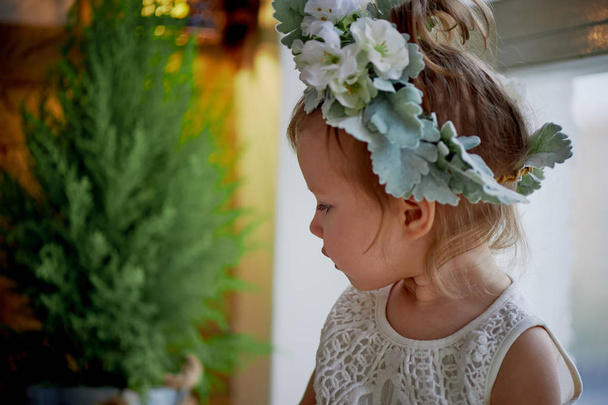 Beautiful little girl in a wreath on the head in green and white. Party dress,  Princess. - Photo, Image