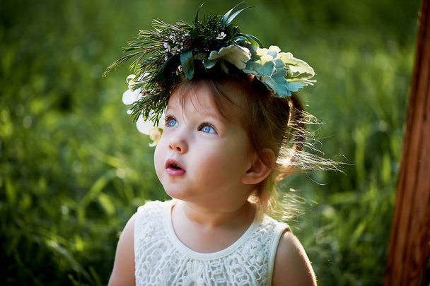 Beautiful little girl in a wreath on the head in green and white. Dress, Princess. - Zdjęcie, obraz