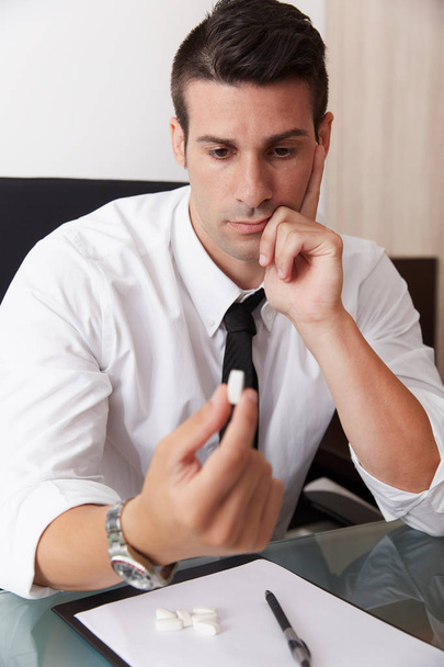Young businessman taking pills - Photo, image