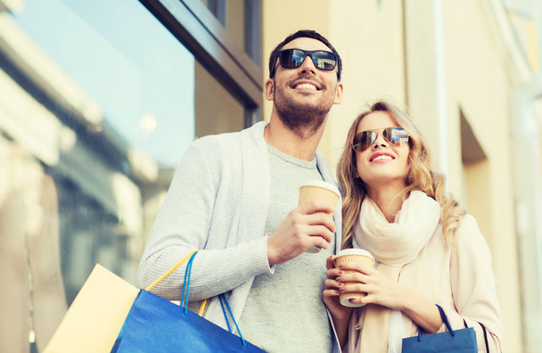 happy couple with shopping bags and coffee in city - Foto, immagini