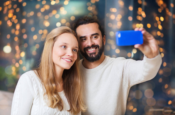 happy couple with smartphone taking selfie - Foto, Imagen