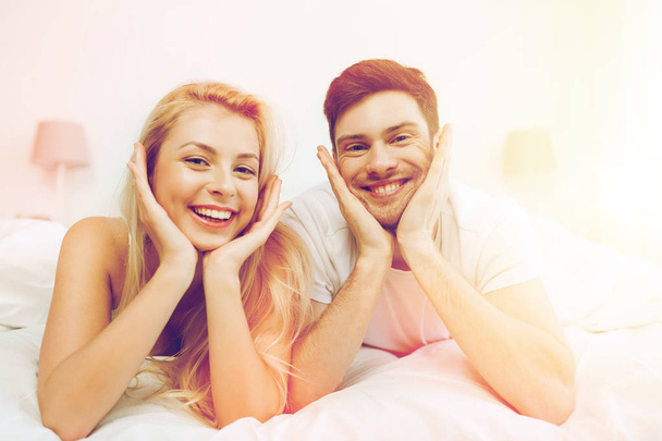 happy couple lying in bed at home - Photo, image