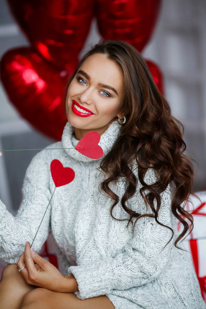 Jonge sexy vrouw met make-up en kapsel, met cadeautjes en ballonnen - Foto, afbeelding
