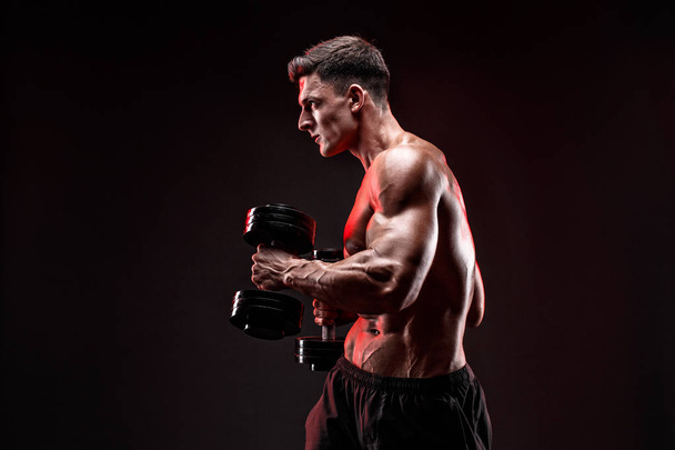 Concentrated muscular man doing exercise with dumbbell - Foto, Imagem
