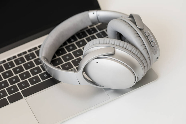 Wireless headphones and laptop computer - Foto, Bild