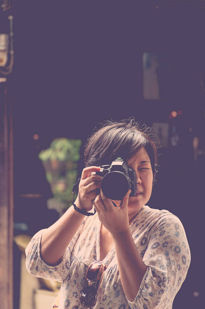 Aasia nainen ottaa kuvan kameralla
 - Valokuva, kuva