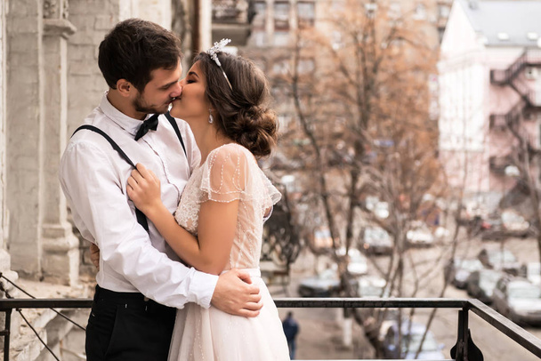 The bride and groom embrace on the balcony. - Foto, Imagen