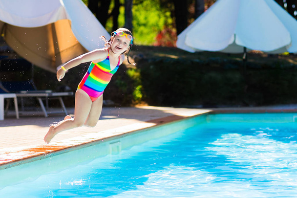 Little girl jumping into swimming pool - Photo, Image