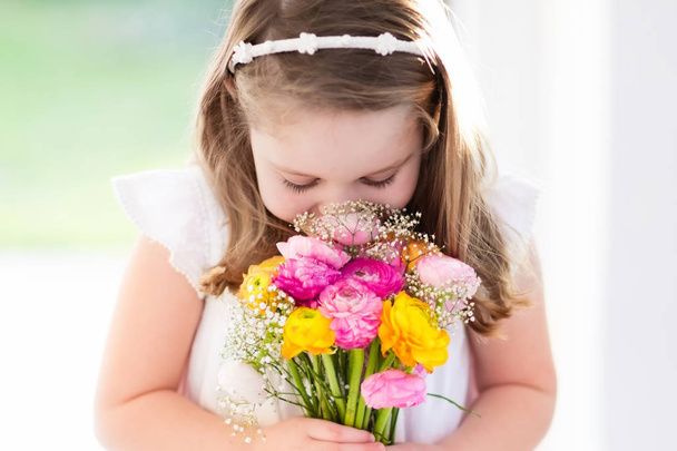 Little girl with flower bouquet - Fotó, kép