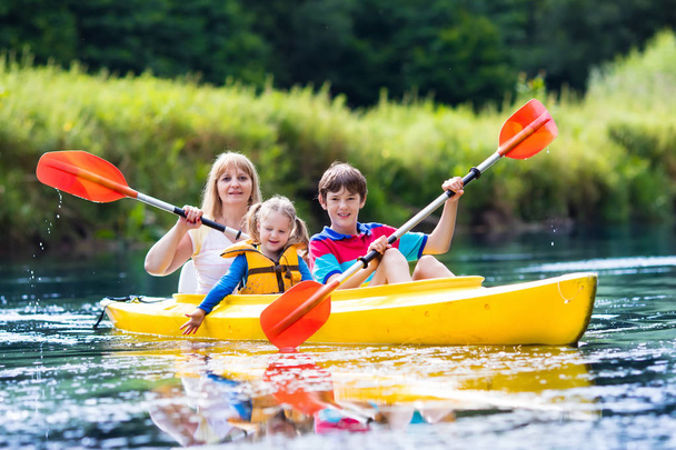 Familia disfrutando del paseo en kayak por un río
 - Foto, imagen