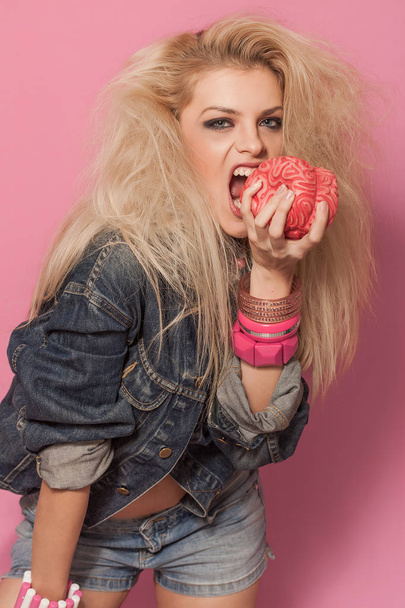 Barbie pop girl portrait holding and eating toy brain - Fotoğraf, Görsel