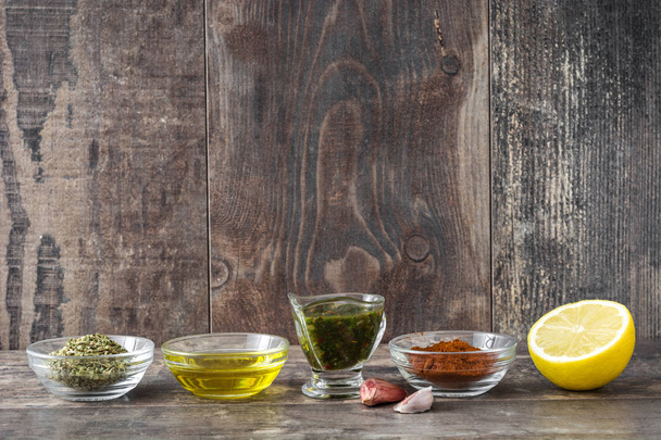 Green Chimichurri Sauce and ingredients on wooden background - 写真・画像