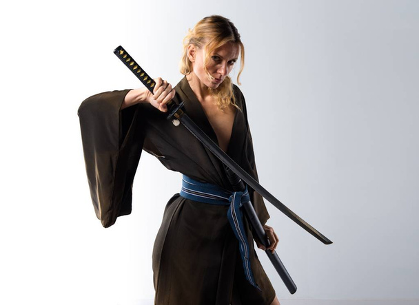 Blonde woman dressed like samurai with a katana - Foto, afbeelding