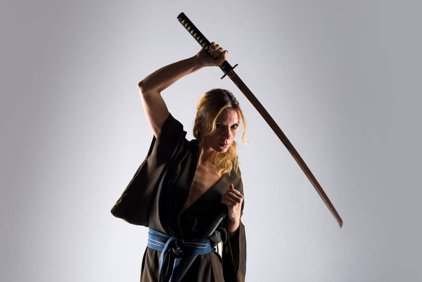 Mulher loira vestida como samurai com uma katana
 - Foto, Imagem