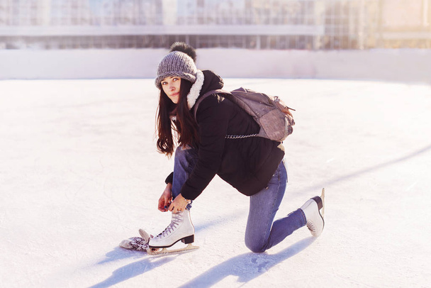 Girl in dress skates mittens tying shoelaces - Foto, Imagem