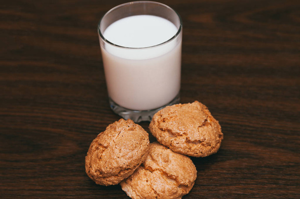 Склянка молока та печива на дерев'яному фоні
 - Фото, зображення