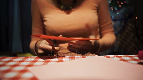 Feminino cortando um cartão vermelho valentine com tesoura
 - Filmagem, Vídeo