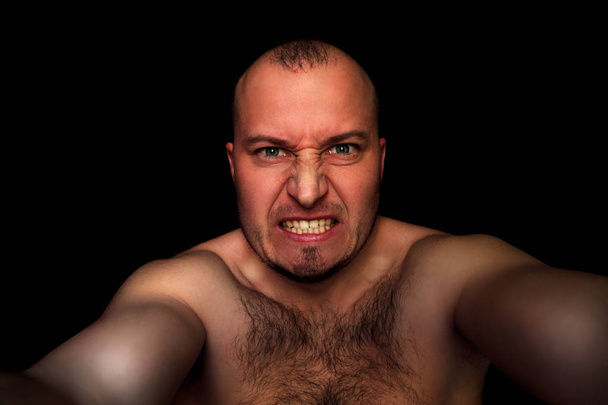 λευκό άνδρα με ένα μορφασμό κακό σε μαύρο φόντο - Φωτογραφία, εικόνα
