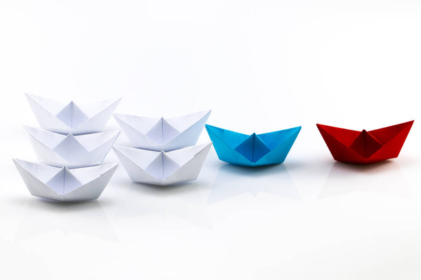 Concepto de liderazgo con el buque de papel rojo líder entre los blancos
 - Foto, Imagen