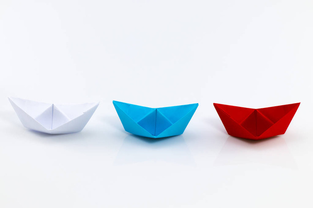 Beyaz arasında önde gelen kırmızı kağıt gemi ile liderlik kavramı - Fotoğraf, Görsel