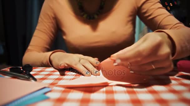 Female making origami from pink paper for valentines day - Footage, Video
