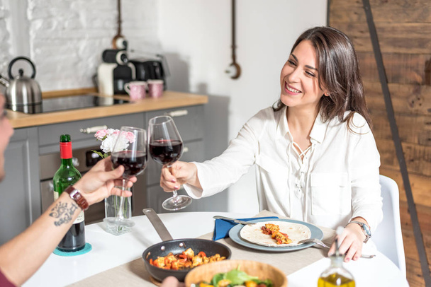 feliz jovem casal comer e beber vinho em casa
  - Foto, Imagem