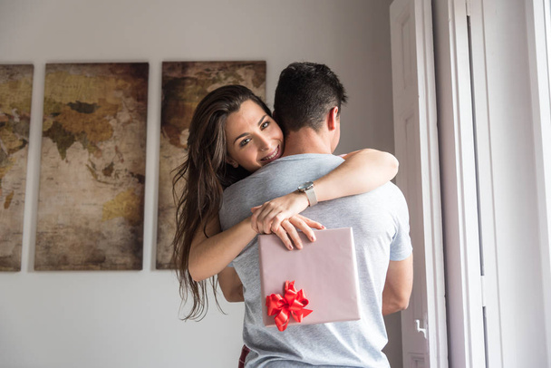 Happy νεαρό ζευγάρι στο αγαπιούνται έκπληξη με τα δώρα  - Φωτογραφία, εικόνα