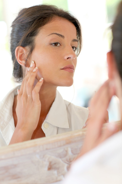 Portrait of woman applying foundation makeup on her face - Foto, Bild