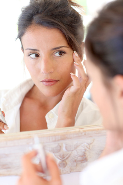Portrait of beautiful woman applying anti-wrinkles cream - Zdjęcie, obraz