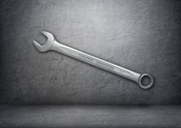 Silver wrench with the words chrome vanadium on the gray concrete wall - 写真・画像