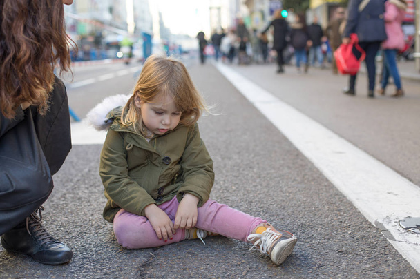niño triste sentado en la calle de asfalto
 - Foto, imagen