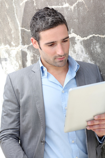 Businessman using electronic tablet outside the office - Fotoğraf, Görsel