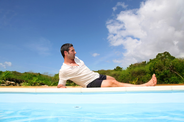 Мужчина делает упражнения у бассейна
 - Фото, изображение