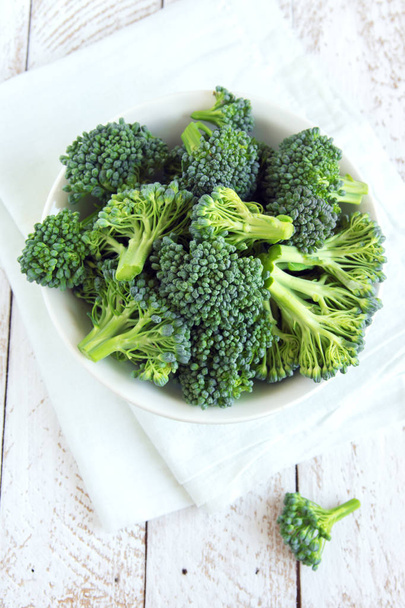 Healthy green organic raw broccoli on wooden table close up - 写真・画像