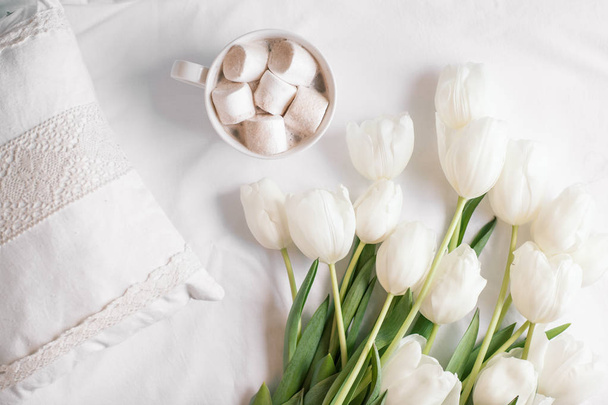 Jarní květiny tulipány s cacao a bílé polštáře - Fotografie, Obrázek