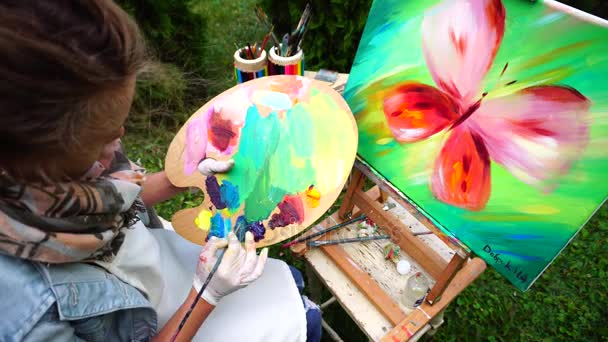 Famale kunstenaar mengt olie kleuren om te beginnen met tekenen schilderen in Park in openlucht. - Video