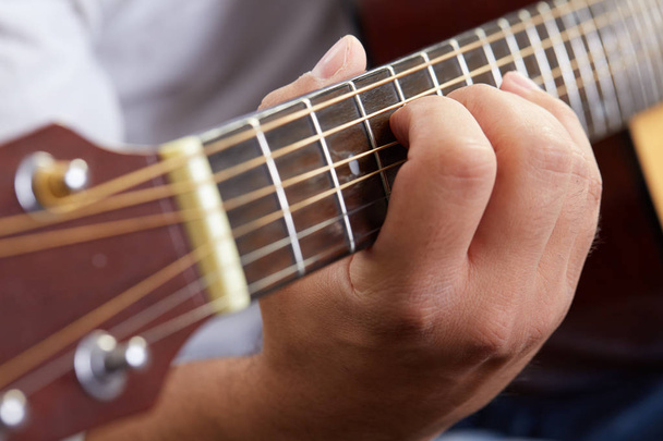 Close up of guitarist hand playing acoustic guitar - Foto, imagen