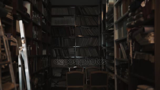 Lights turns on in old style library interior. Stepladder, books and folders - Footage, Video