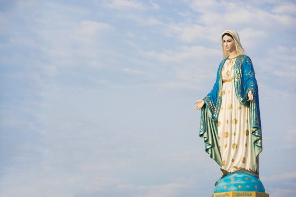 Standbeeld van de Maagd Maria met blauwe hemelachtergrond - Foto, afbeelding