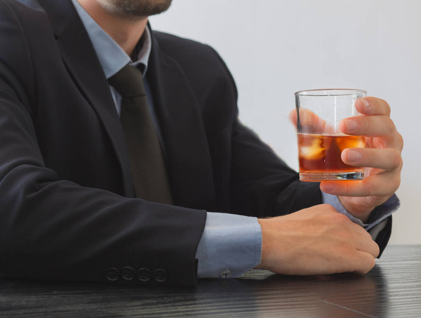 Man in suit holding glass of Whiskey. - Zdjęcie, obraz
