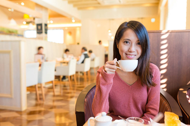 Žena si jí nápoj v kavárně - Fotografie, Obrázek