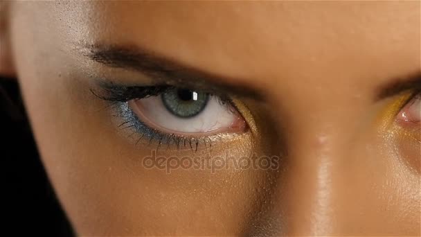 Meisje met grijze ogen met mooie make-up kijkt een fascinerende blik in de verte. Close-up. Slow motion - Video