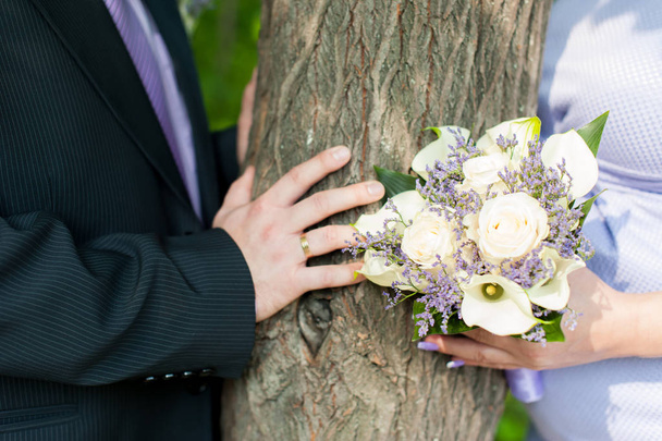 bridal bouquet and newlyweds rings. hands adult honeymooners close up - Foto, Imagem