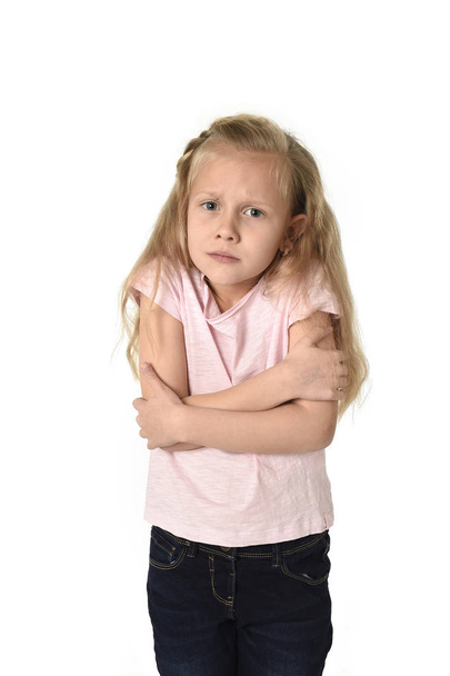 jonge kind meisje met koude gebaren en beven geïsoleerd op witte achtergrond - Foto, afbeelding