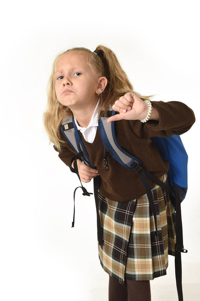 beautiful little schoolgirl tired and exhausted carrying on her back heavy school backpack looking sad - Foto, imagen