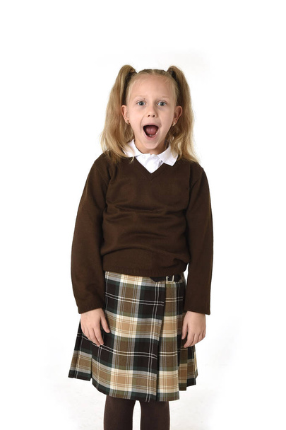 sladká školačka v copánky a školní uniformu, hledají ohromen, šokován a překvapen - Fotografie, Obrázek